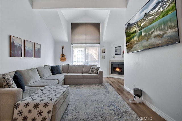 living room with high vaulted ceiling, wood-type flooring, and a tile fireplace