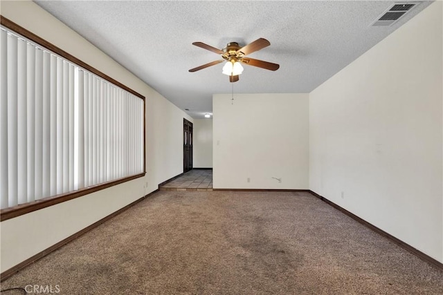 carpeted spare room featuring a textured ceiling and ceiling fan