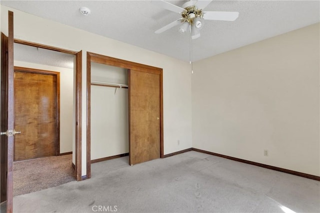 unfurnished bedroom featuring ceiling fan, light colored carpet, a textured ceiling, and a closet