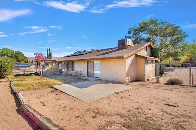 rear view of house featuring solar panels, a patio area, and central air condition unit