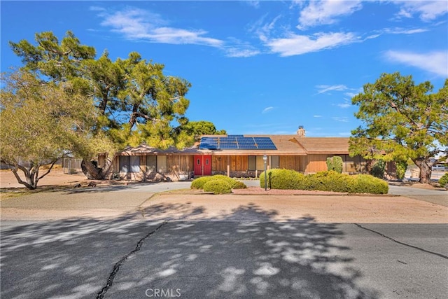 ranch-style house with solar panels