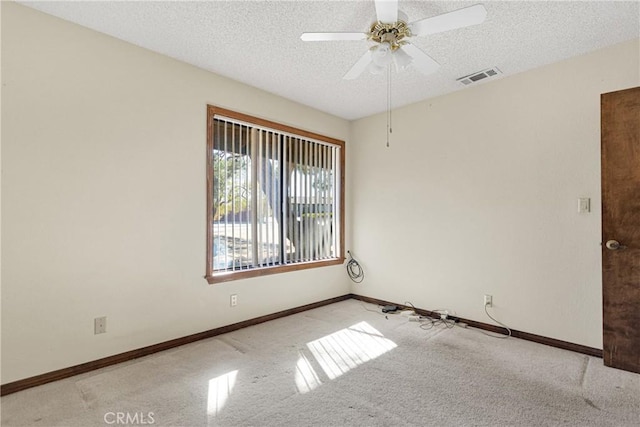 carpeted empty room with ceiling fan and a textured ceiling