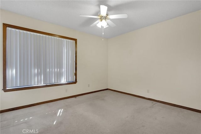 spare room with ceiling fan and light carpet