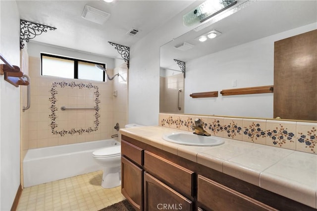 full bathroom with vanity, tiled shower / bath combo, toilet, and backsplash