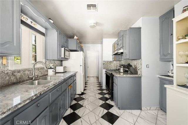 kitchen featuring appliances with stainless steel finishes, gray cabinetry, and sink