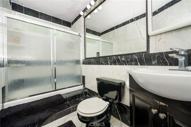 bathroom with tile patterned flooring, vanity, toilet, and tile walls