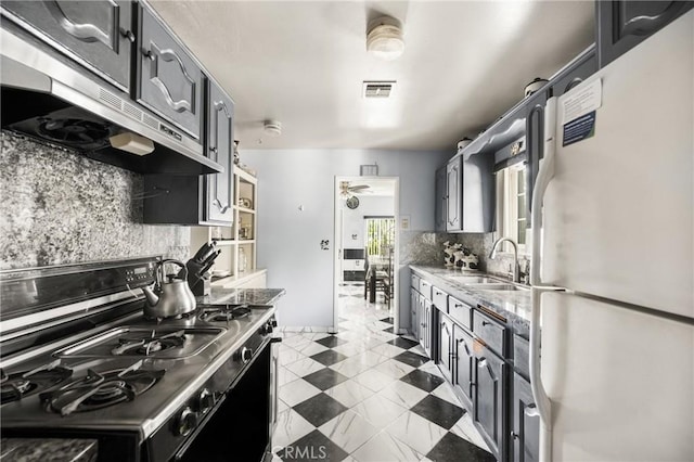 kitchen featuring black gas range, white refrigerator, sink, decorative backsplash, and ceiling fan