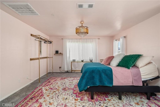 carpeted bedroom with an inviting chandelier