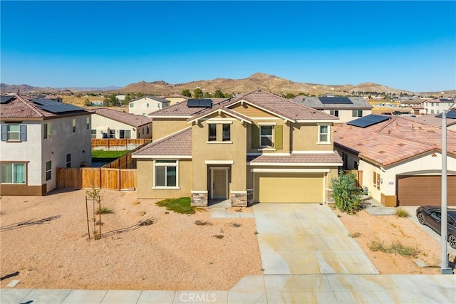 view of front of home with a mountain view, solar panels, a garage, and central AC unit