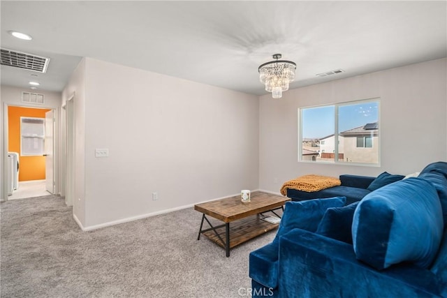 carpeted living room featuring an inviting chandelier