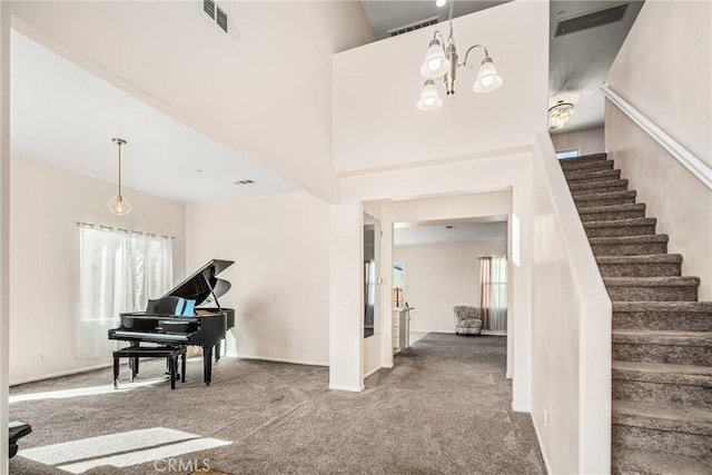 entrance foyer featuring a high ceiling, carpet floors, and a notable chandelier