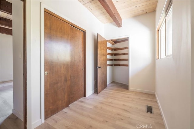 hallway featuring beamed ceiling, light hardwood / wood-style floors, and wood ceiling