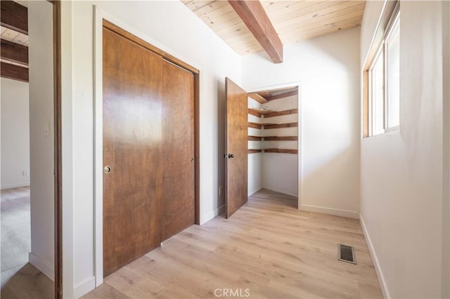 corridor with wood ceiling, visible vents, beamed ceiling, and light wood-style flooring