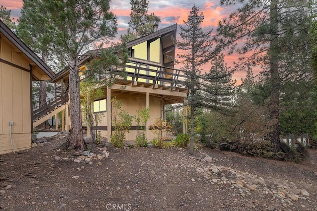 back house at dusk featuring a balcony