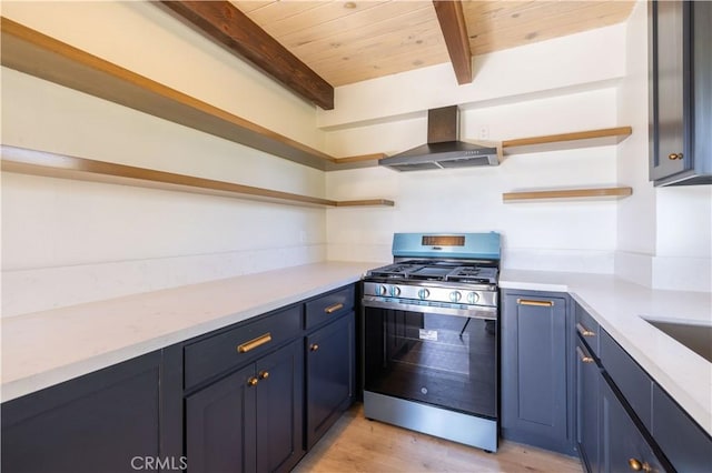 kitchen featuring beamed ceiling, stainless steel range with gas stovetop, wood ceiling, and wall chimney range hood