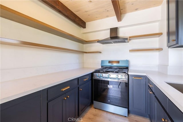 kitchen featuring blue cabinets, wall chimney range hood, open shelves, beamed ceiling, and gas stove