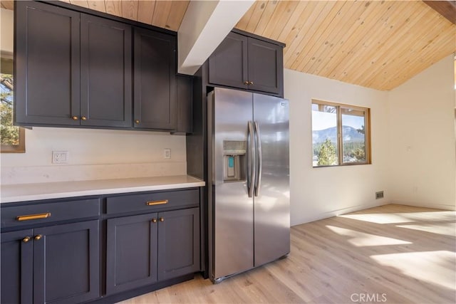 kitchen featuring lofted ceiling, stainless steel fridge, wooden ceiling, and light hardwood / wood-style flooring