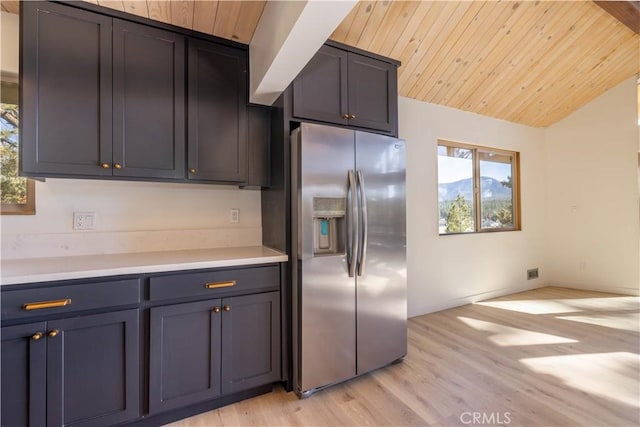 kitchen featuring wooden ceiling, plenty of natural light, and stainless steel refrigerator with ice dispenser