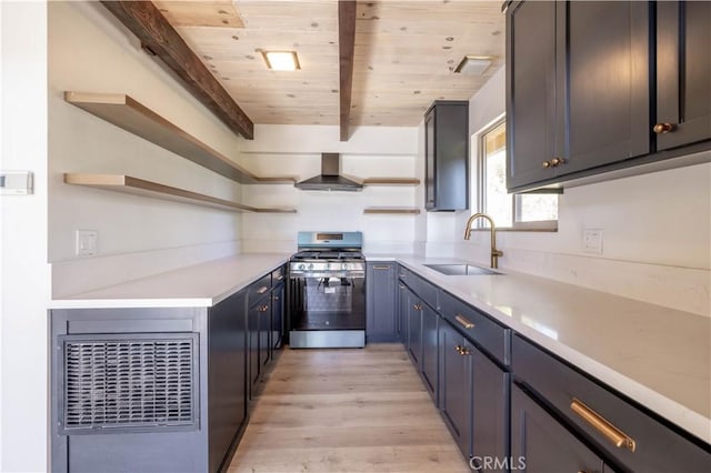 kitchen featuring sink, wall chimney exhaust hood, stainless steel range with gas cooktop, light hardwood / wood-style flooring, and beamed ceiling