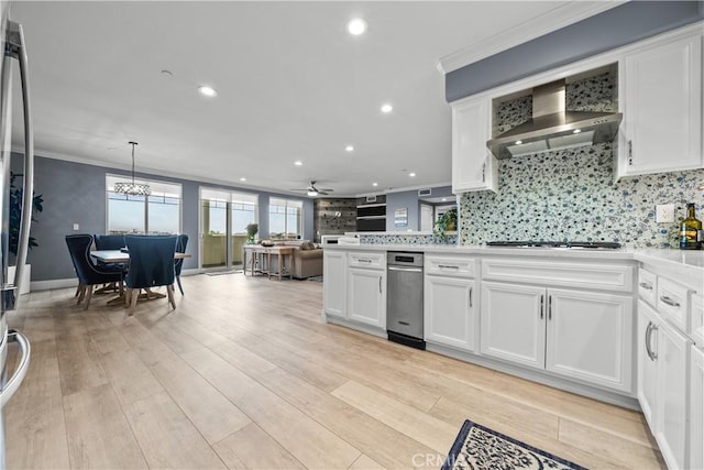 4344 Tradewinds Dr, Oxnard, CA 93035 - kitchen with recessed lighting, white cabinetry, wall chimney range hood, a ceiling fan, and crown molding