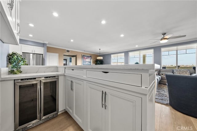 4344 Tradewinds Dr, Oxnard, CA 93035 - kitchen with beverage cooler, stainless steel refrigerator, ornamental molding, white cabinets, and recessed lighting