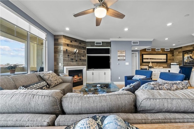 4344 Tradewinds Dr, Oxnard, CA 93035 - living room featuring wood walls, ornamental molding, recessed lighting, a ceiling fan, and a glass covered fireplace