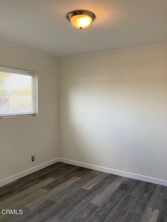 empty room with ornamental molding and dark hardwood / wood-style floors