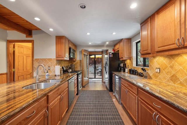 kitchen featuring light stone counters, sink, light hardwood / wood-style floors, and appliances with stainless steel finishes