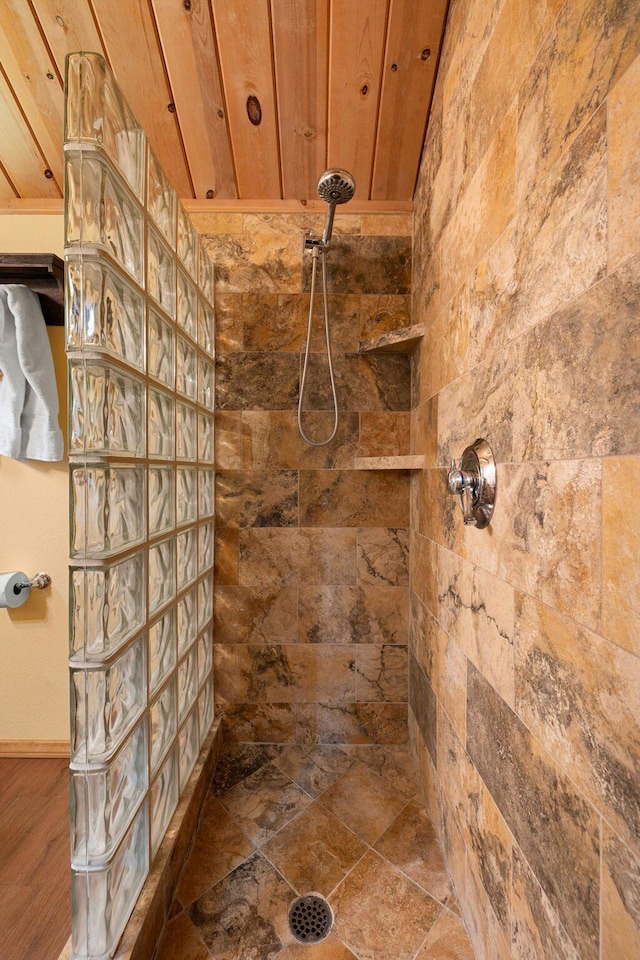 bathroom with a tile shower and wooden ceiling