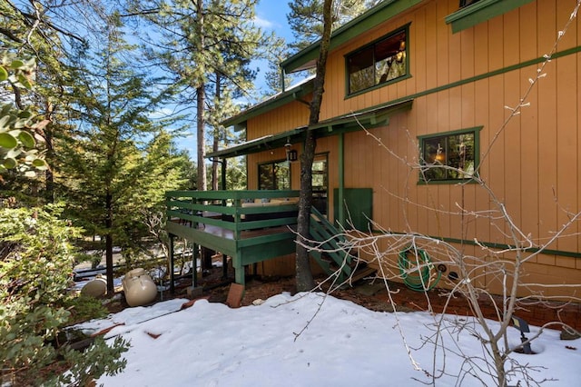 view of snowy exterior featuring a wooden deck