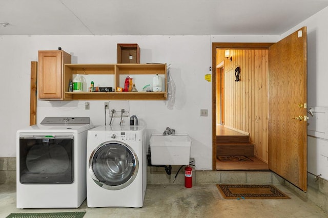 washroom featuring cabinets, sink, and independent washer and dryer