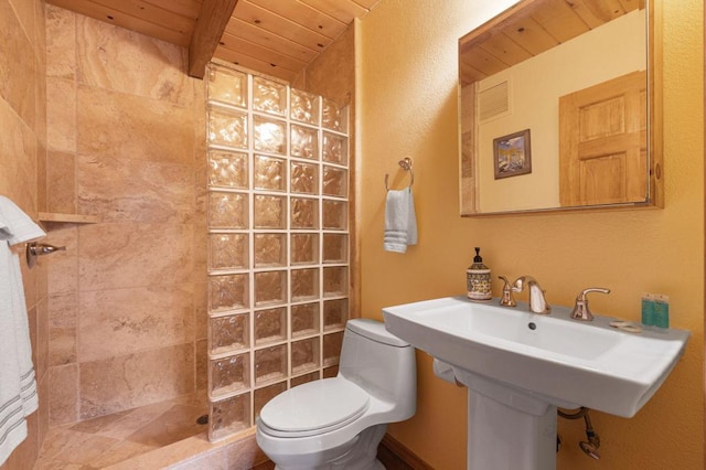 bathroom with sink, tiled shower, wooden ceiling, toilet, and beamed ceiling