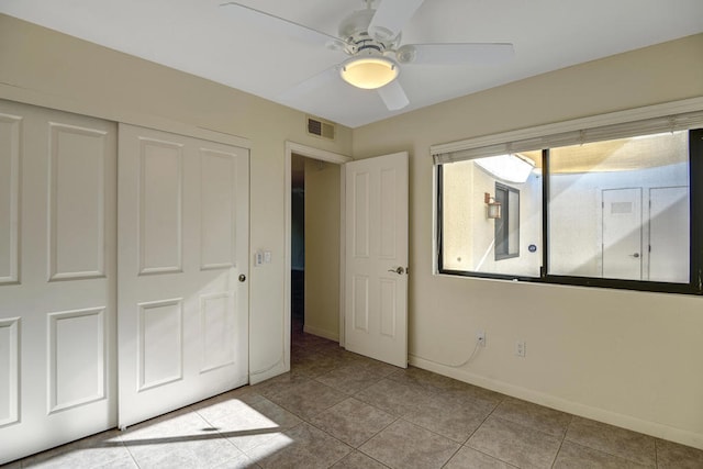 unfurnished bedroom with a closet, ceiling fan, and light tile patterned floors