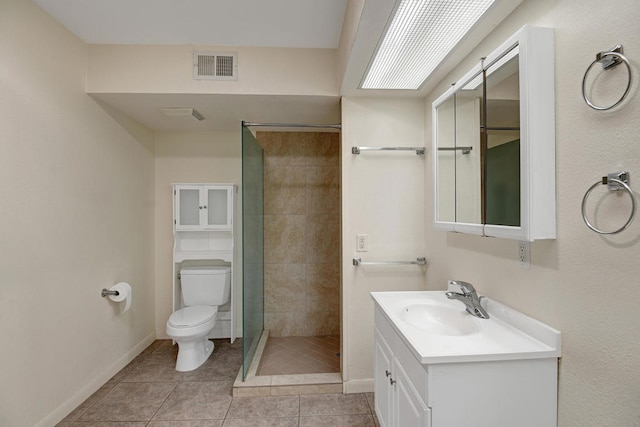 bathroom featuring vanity, toilet, tile patterned floors, and a tile shower