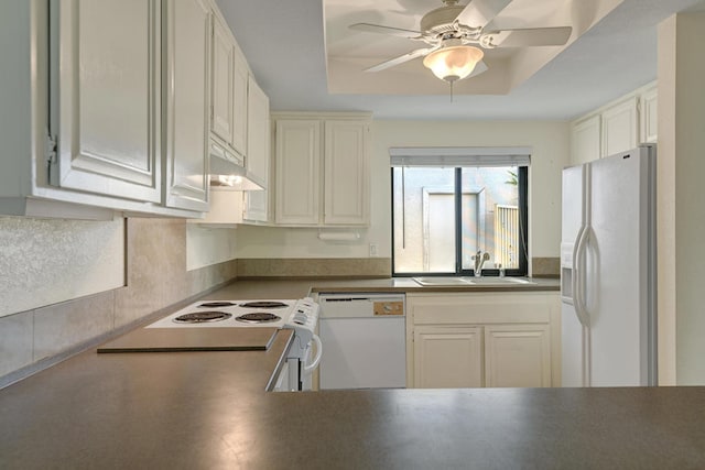 kitchen with sink, white cabinets, a tray ceiling, and white appliances