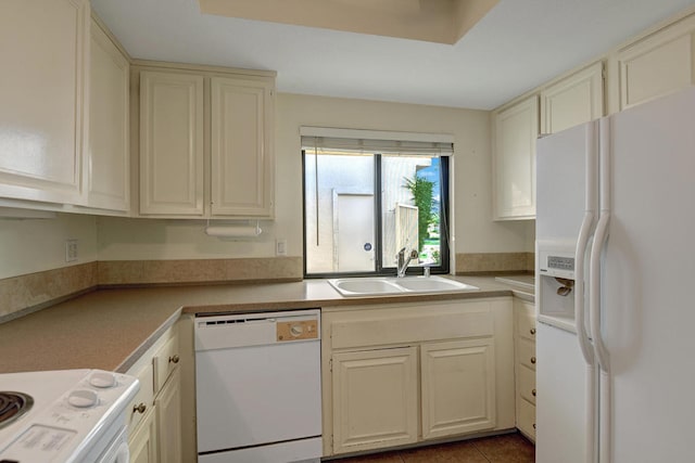 kitchen featuring tile patterned floors, sink, cream cabinetry, and white appliances