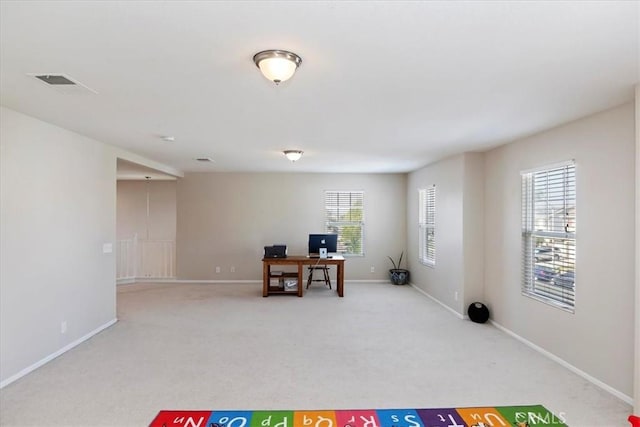 interior space with light colored carpet, visible vents, and baseboards