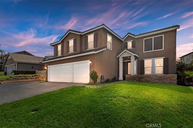 view of front of home with a yard and a garage