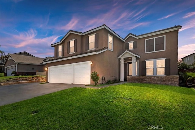 traditional home featuring a garage, concrete driveway, a front lawn, and stucco siding