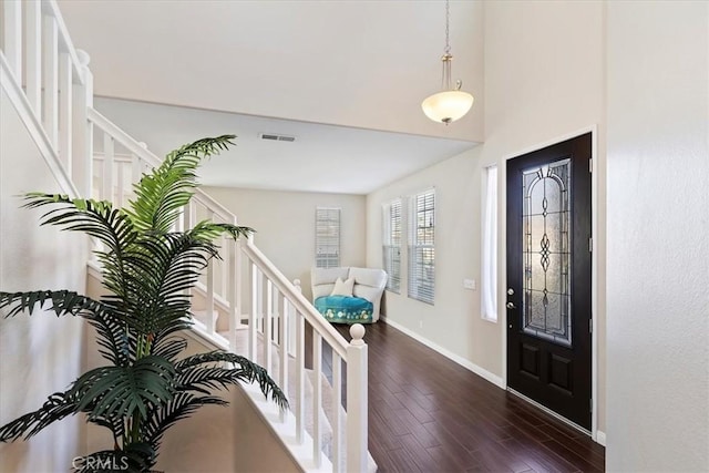 foyer entrance featuring visible vents, stairs, baseboards, and dark wood-style flooring