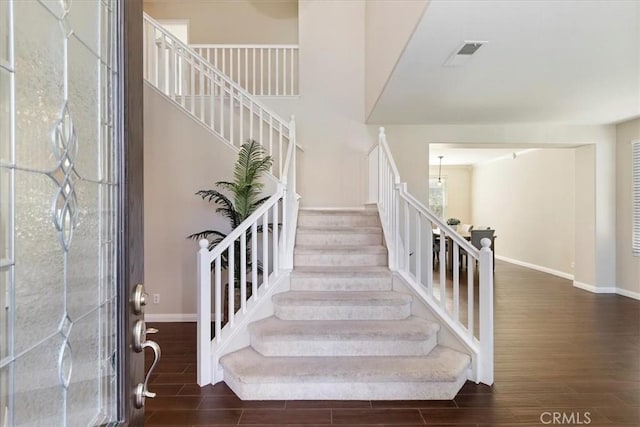 entryway featuring baseboards, stairway, visible vents, and wood tiled floor