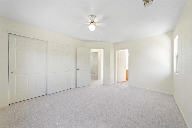 unfurnished bedroom with ceiling fan, a closet, and light colored carpet