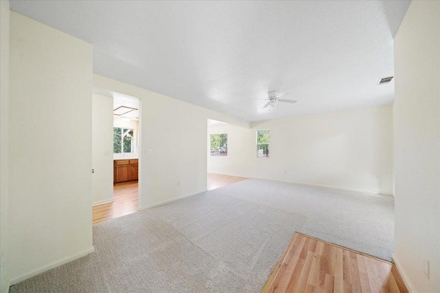 spare room with ceiling fan and light carpet