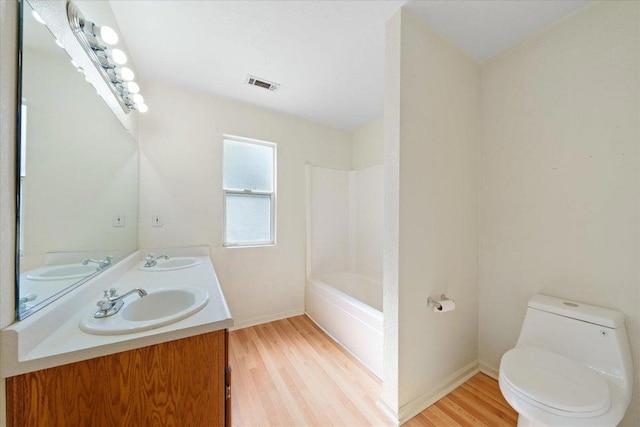 bathroom with toilet, hardwood / wood-style flooring, and vanity