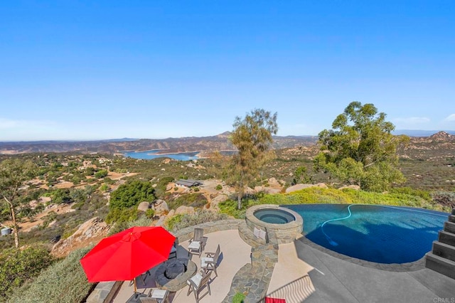 view of swimming pool with a water view and a patio