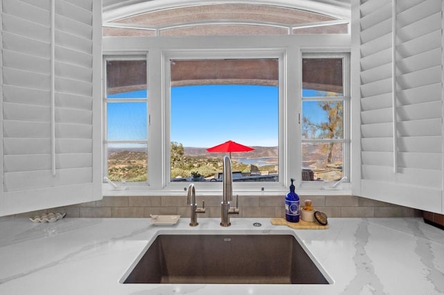 details featuring light stone countertops and sink