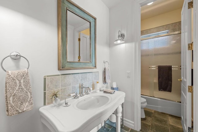 bathroom featuring shower / bath combination with glass door, backsplash, and toilet