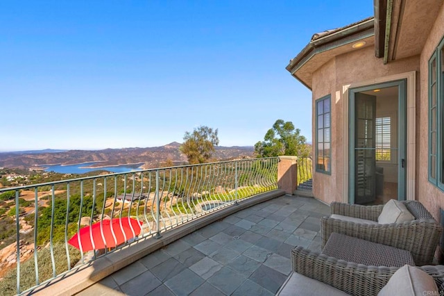 balcony featuring a water and mountain view