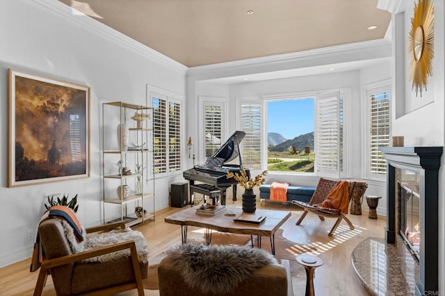 sitting room with crown molding, a high end fireplace, and light hardwood / wood-style floors