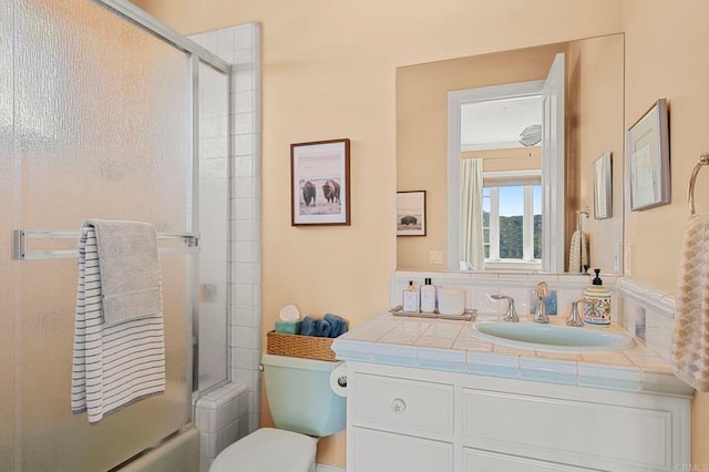 full bathroom featuring vanity, toilet, and combined bath / shower with glass door